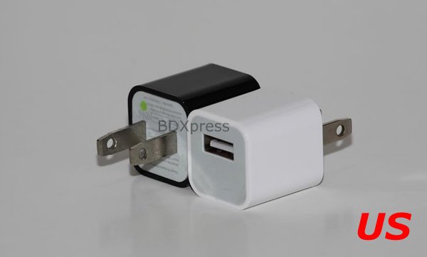 Two of the cube-shaped adapters are shown side-by-side - one black, and one white. Both have standard U.S. wall plugs and a single USB A port on the front.