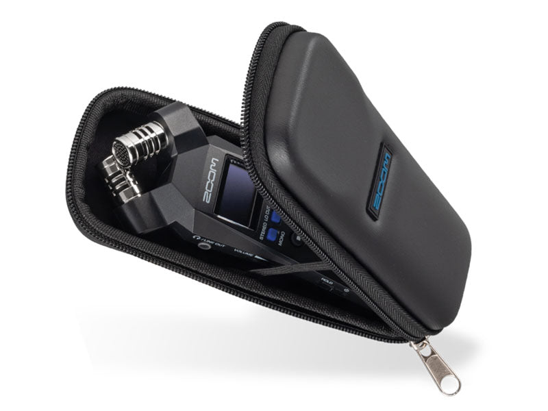 Zoom H1 Essentials recorder partially zipped inside a black, hard-shell protective case with a silver zipper pull and blue logo on the exterior."