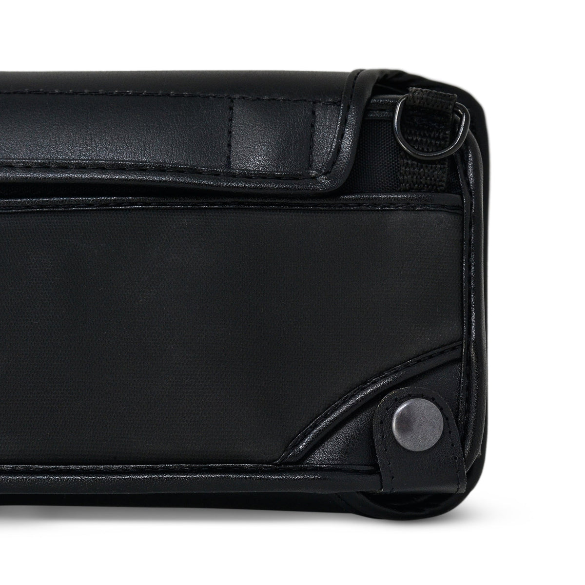Close-up of the Brailliant BI 40X case's back corner showing black metal carrying ring, leather stitching and snap-fastened strap.