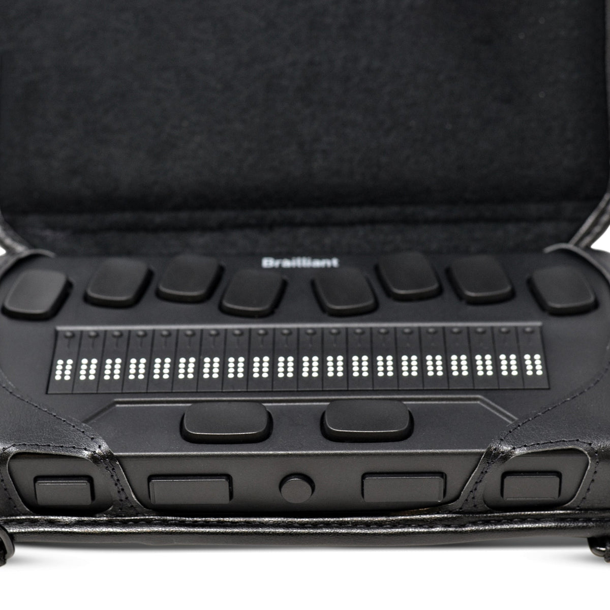 Close-up of a 20-cell braille display in the open Brailliant BI 20X carrying case, showing accessible braille cells and front navigation buttons.