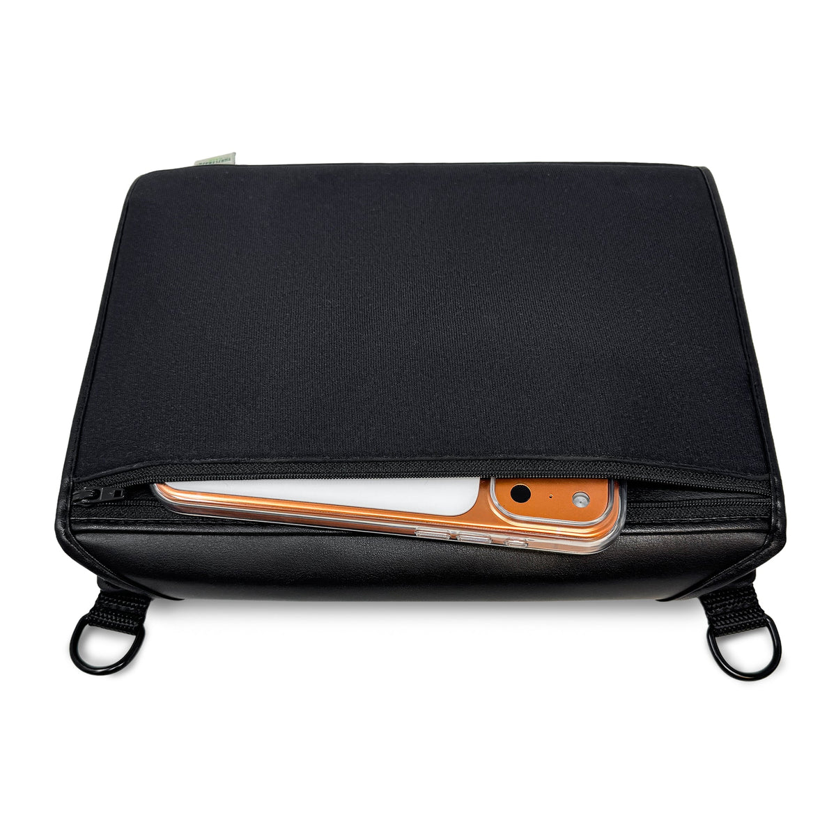 Closed BrailleNote Evolve case with its front zippered pocket partly open to show a smartphone stored inside, and carrying rings at the bottom.