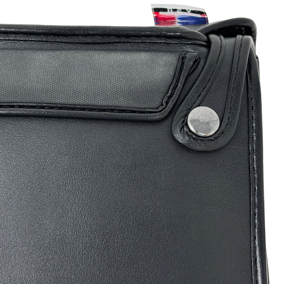 Close-up of the rear upper corner of the BrailleNote Evolve case, showing a metal snap fastening and the stitched leather flap.