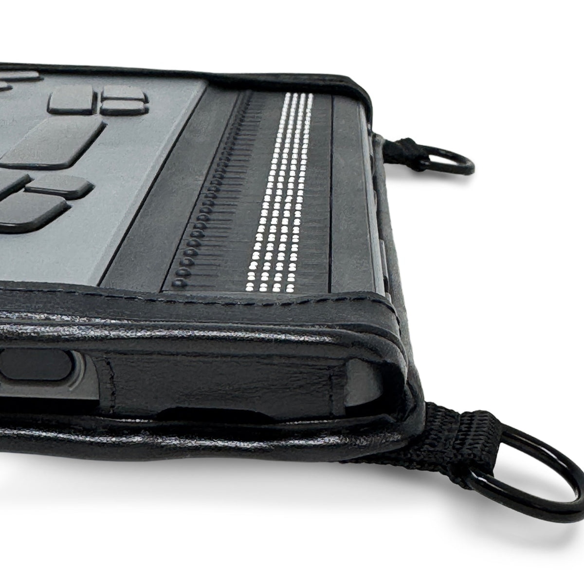 Close-up of the BrailleNote Evolve braille cells and the stitched corner of the black fitted case, showing its protective edge and strap ring.