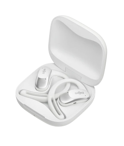 White Shokz OpenFit Air wireless earbuds resting inside an open charging case. The earbuds are neatly coiled.