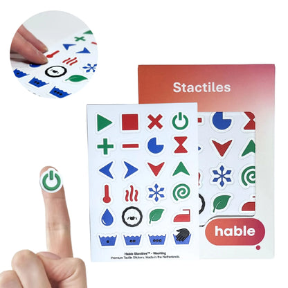 Stactiles Washing tactile sticker sheet with 24 colorful laundry symbols, shown with Hable packaging and a power sticker on a fingertip.