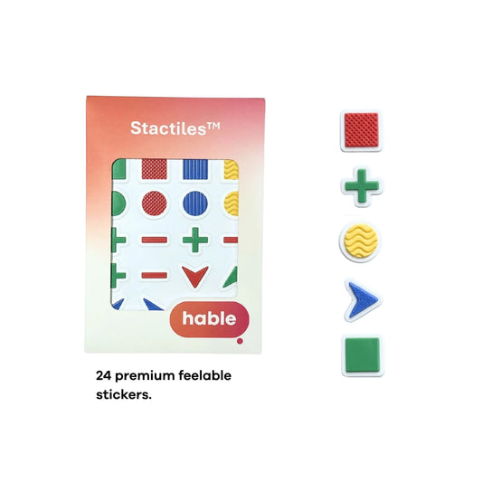 A composite image showcasing the Stactiles Basic Shapes set. A circular inset in the top-left shows fingers feeling different textured stickers. In the bottom-left, a blue textured chevron sticker is shown on a fingertip for scale. The center features a full sheet of 24 stickers in green, red, blue, and yellow. Shapes include triangles, squares, circles, pluses, minuses, and chevrons, many of which feature unique tactile patterns like vertical ridges, cross-hatching, and wavy lines.